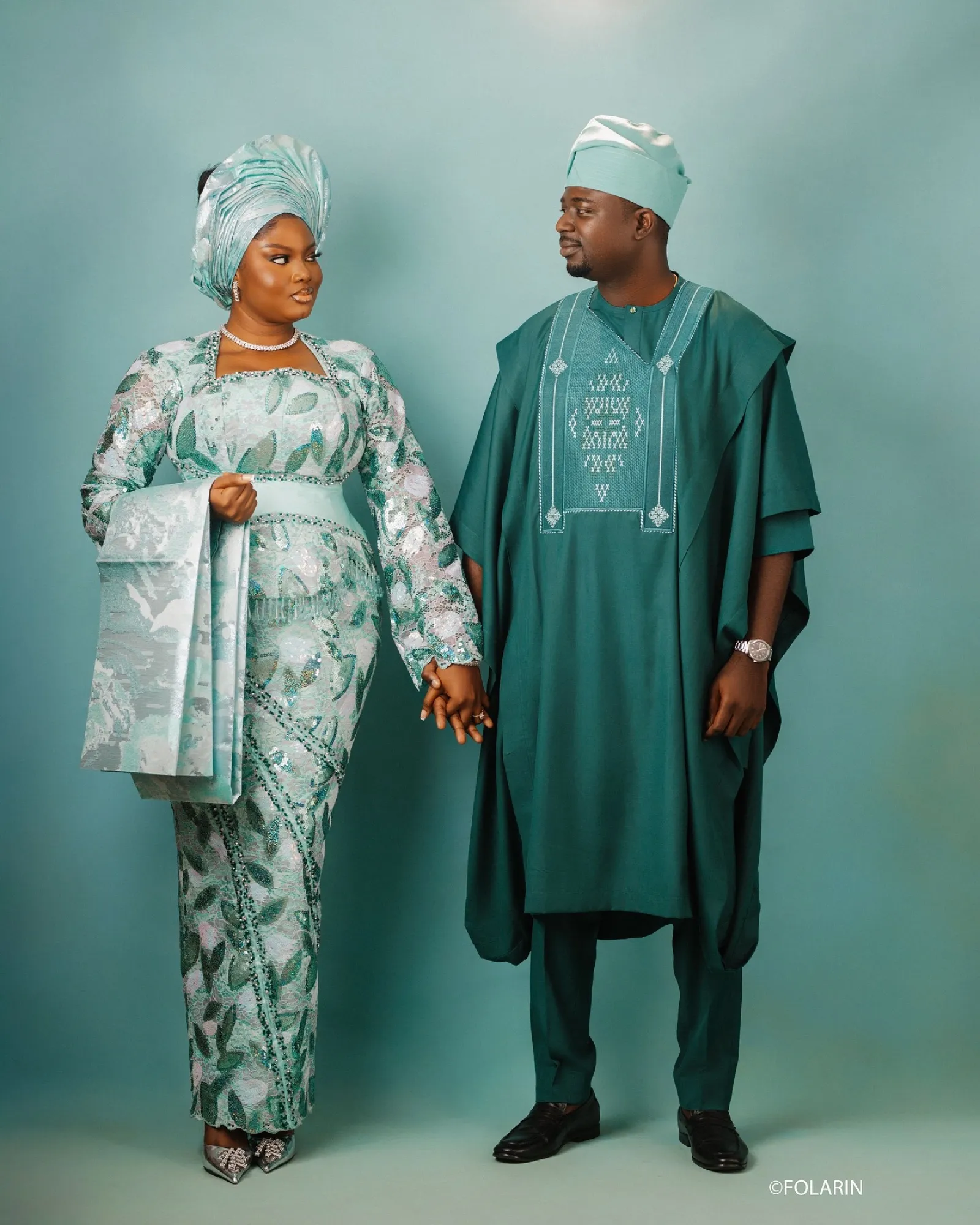 The couple in teal and green holding hands