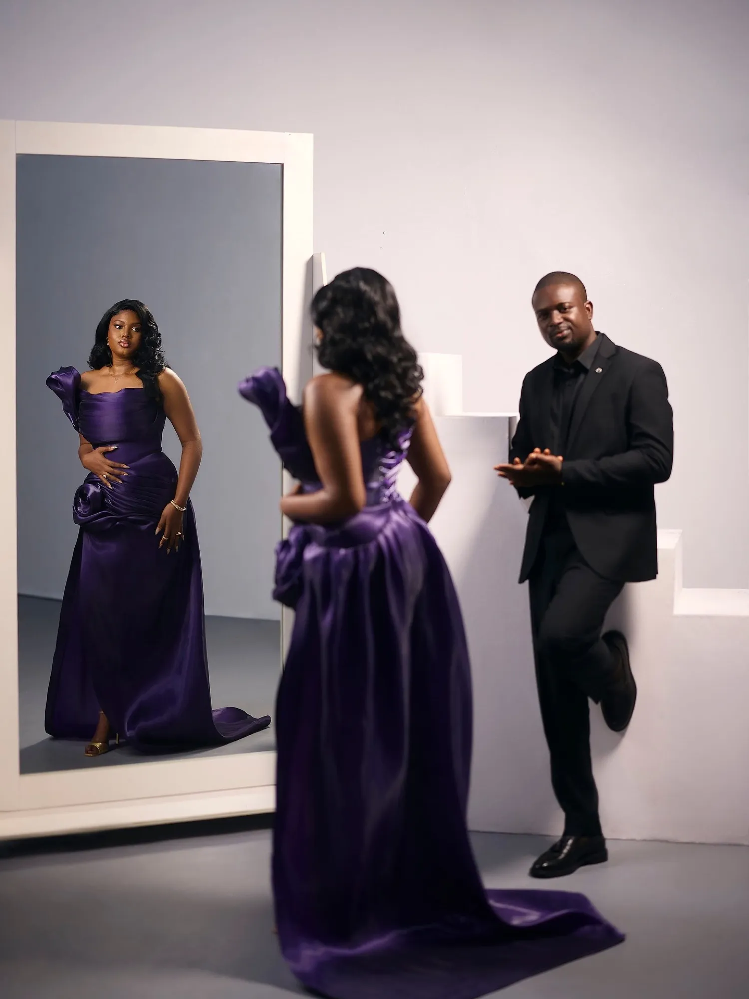 Purple gown and black suit in a white studio