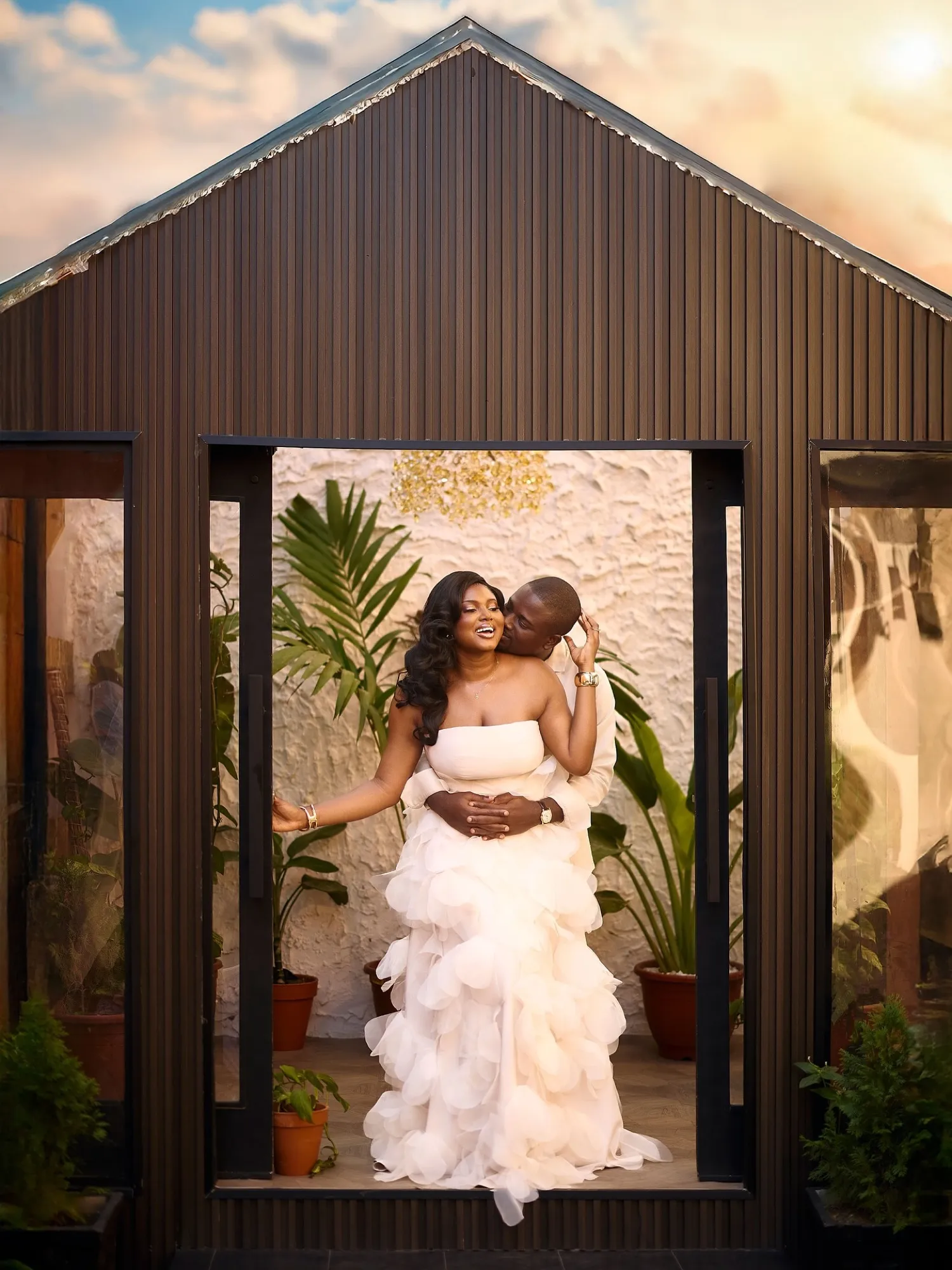 Bride in a tiered white gown framed by a glass doorway