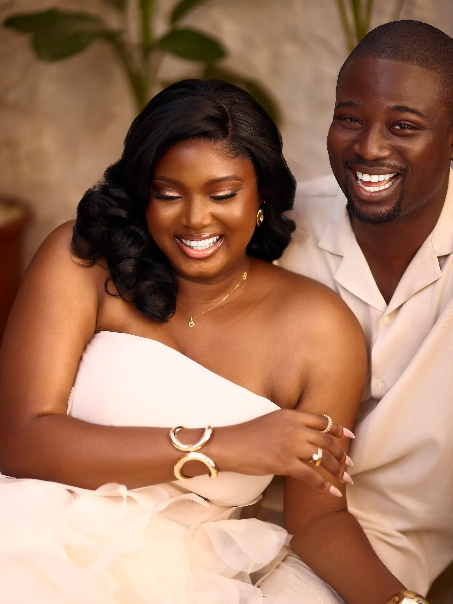 The couple laughing in ivory, bride in a ruffled gown