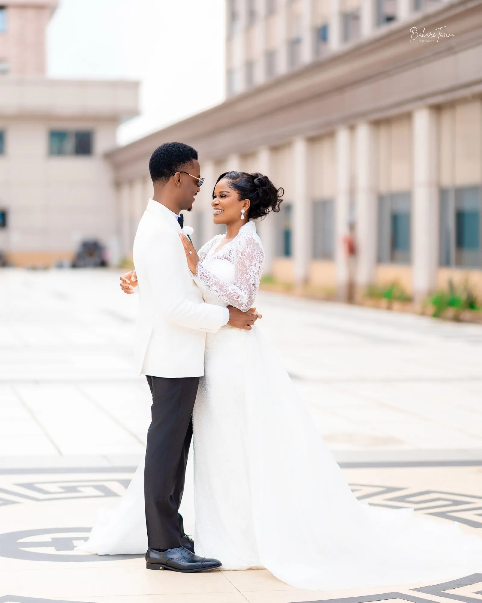 The couple embracing in a sunlit courtyard