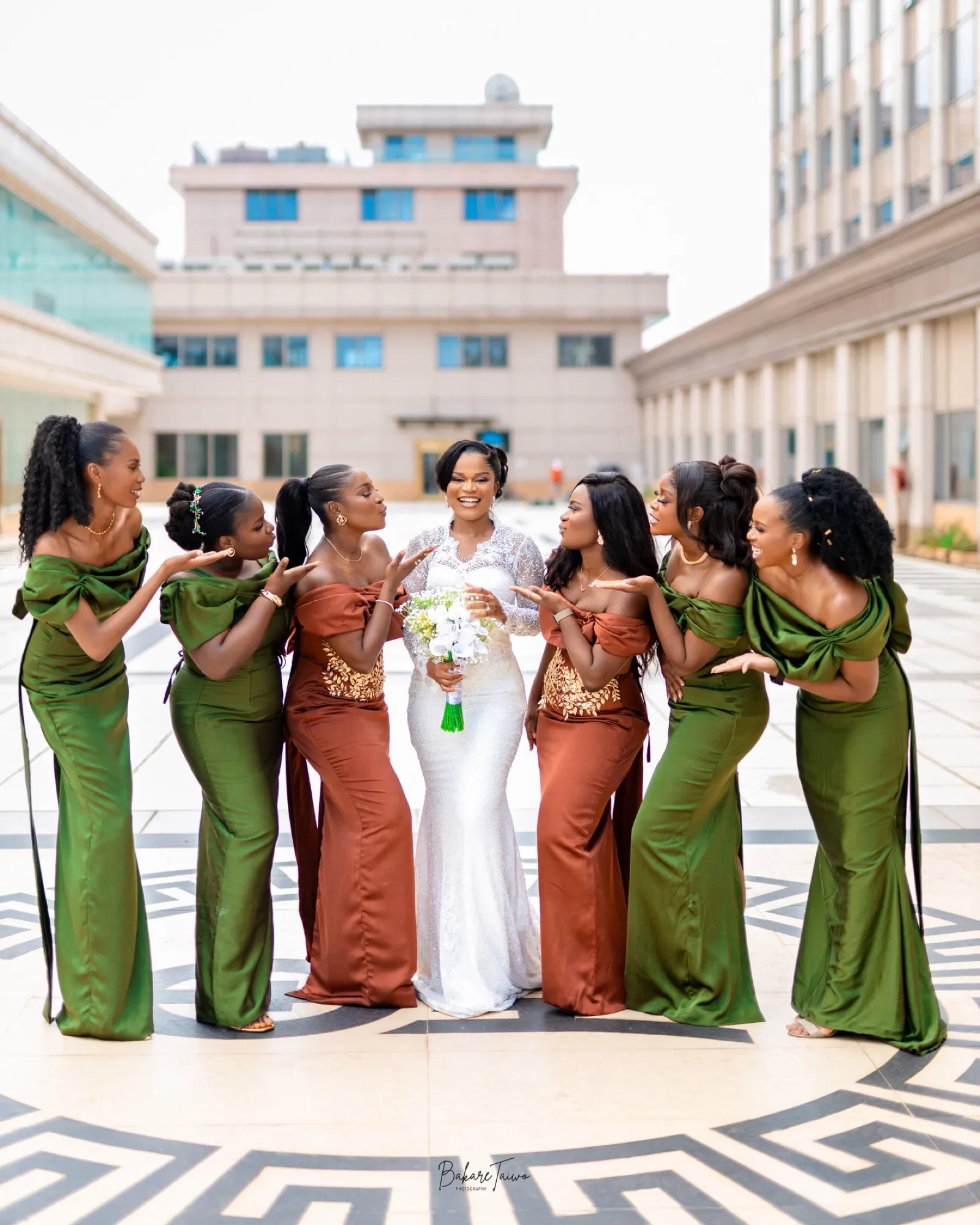 Bride with bridesmaids in emerald and rust on a Greek-key courtyard
