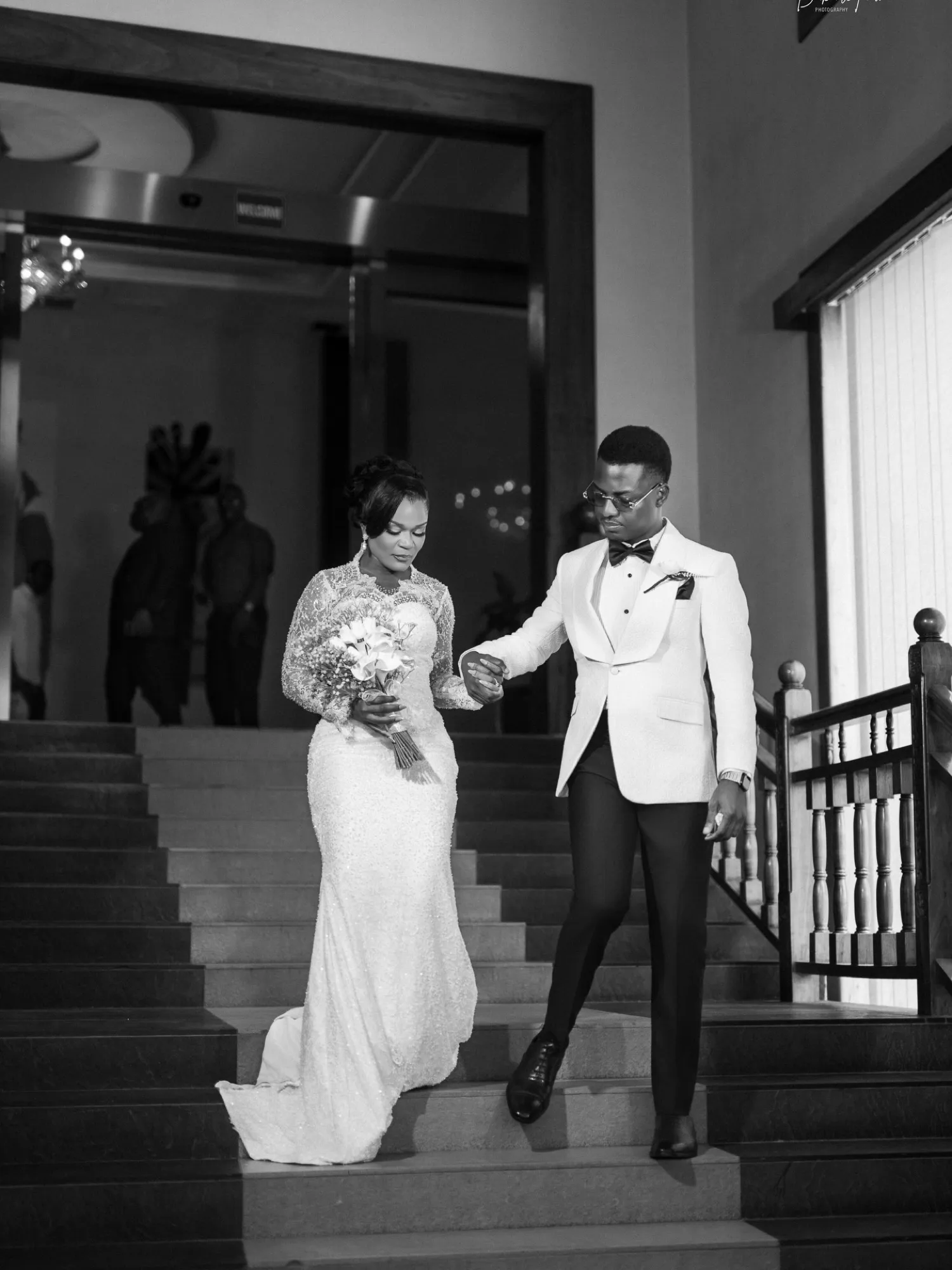Black and white shot of the couple walking down the stairs
