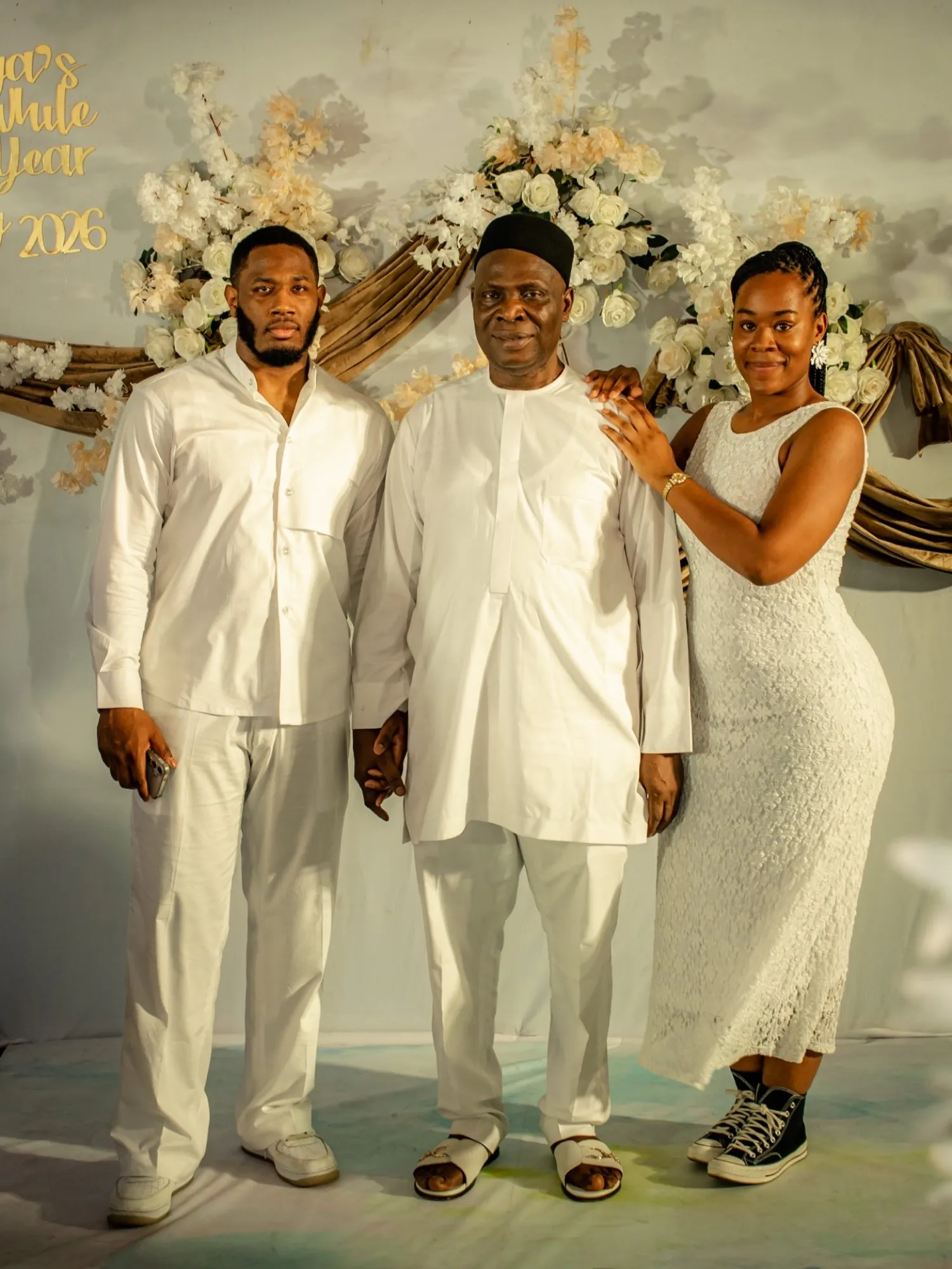 The host family in white under the floral arch