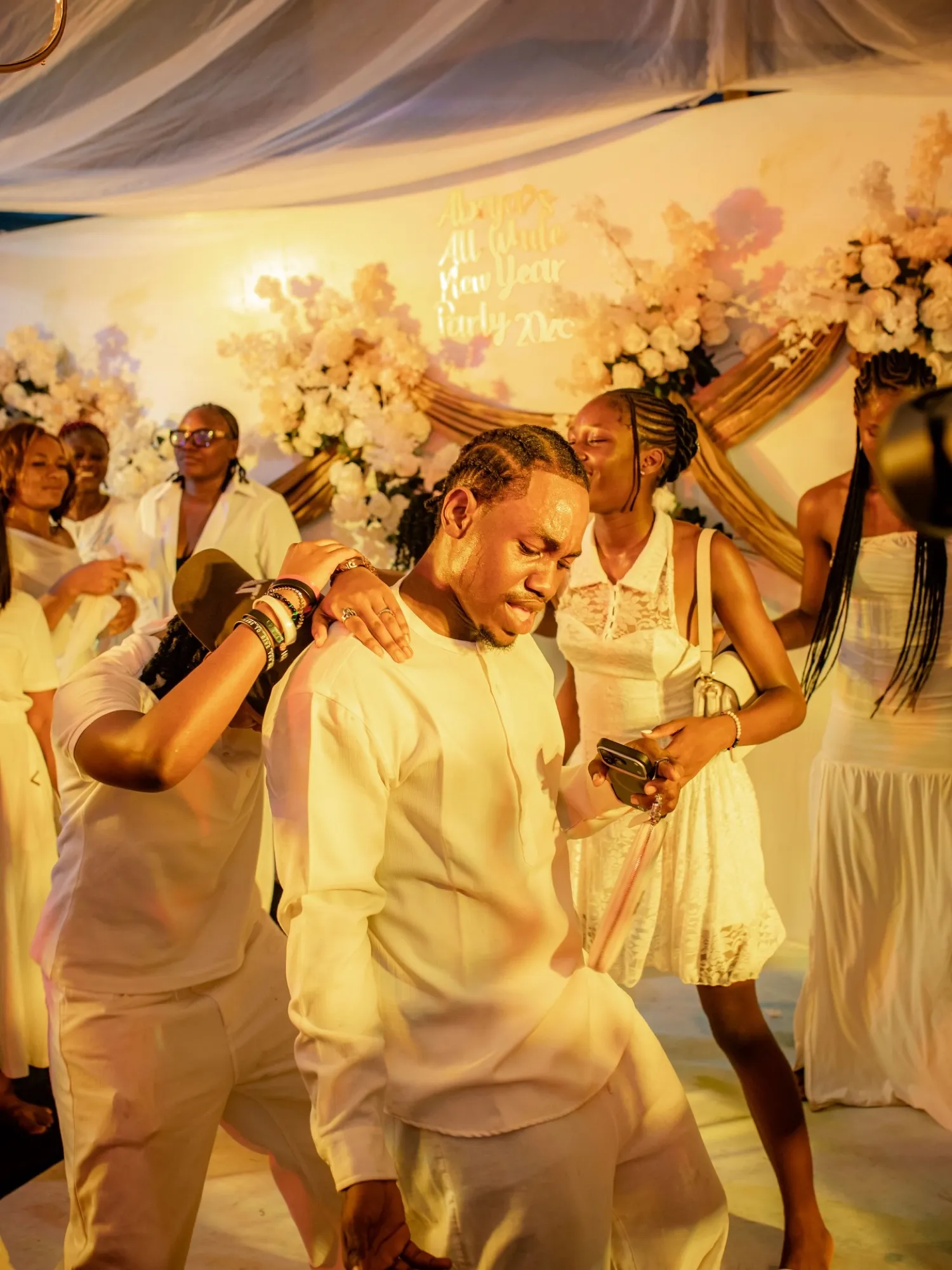 A guest dancing with a fan in front of the floral backdrop