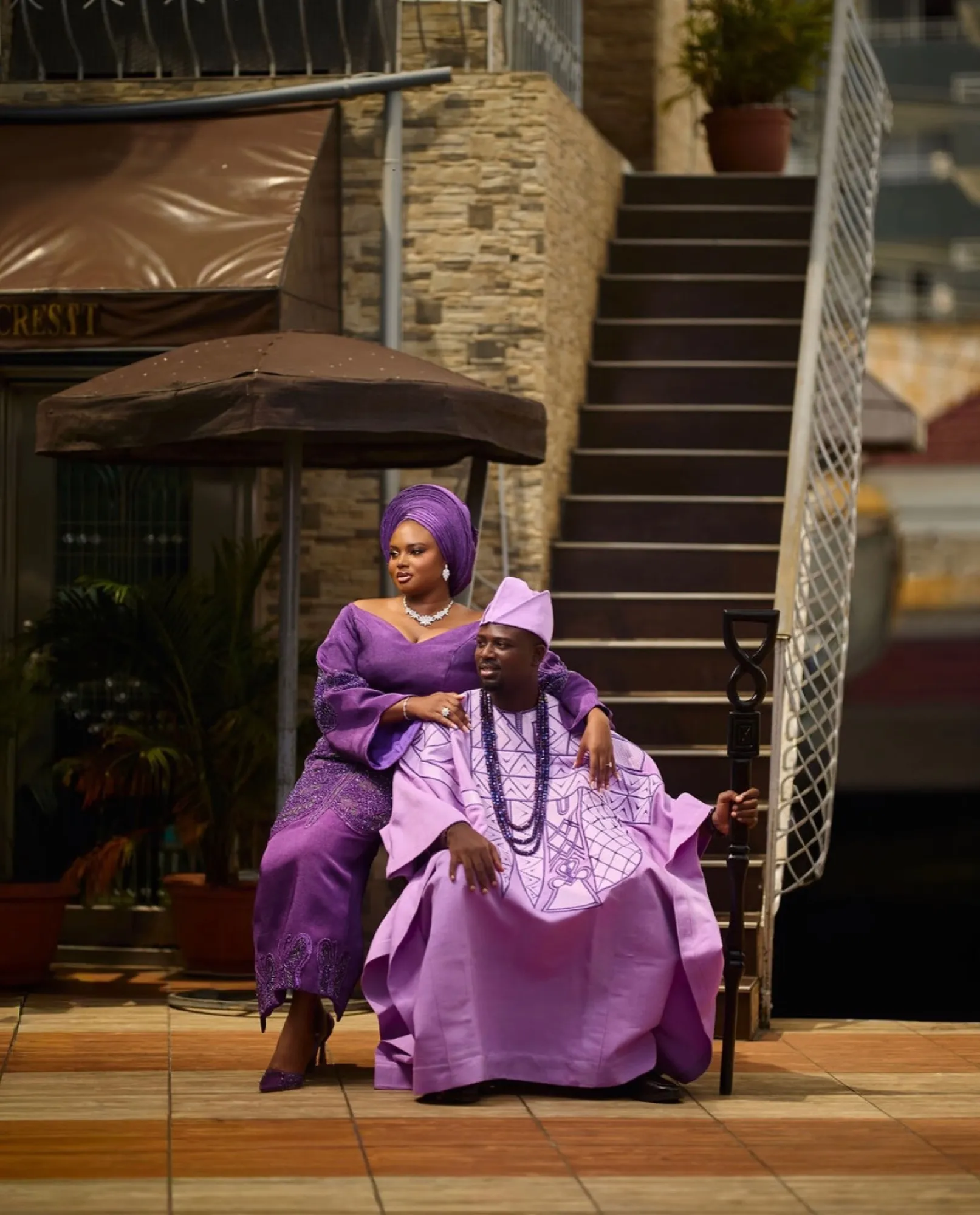 Family in lilac and purple aso-oke seated outside the venue