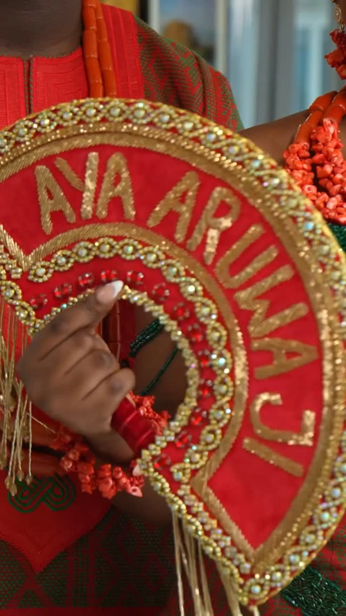 A red beaded hand fan held close