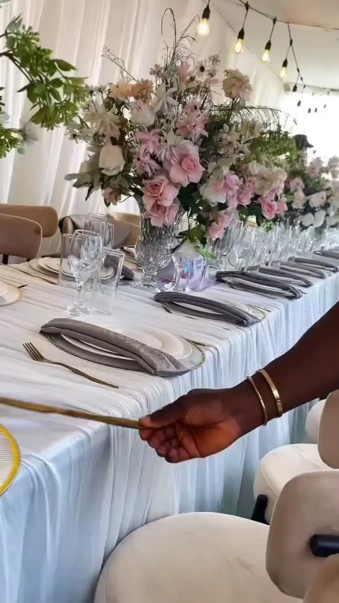 Long table with blush florals, gold-rimmed plates and folded napkins