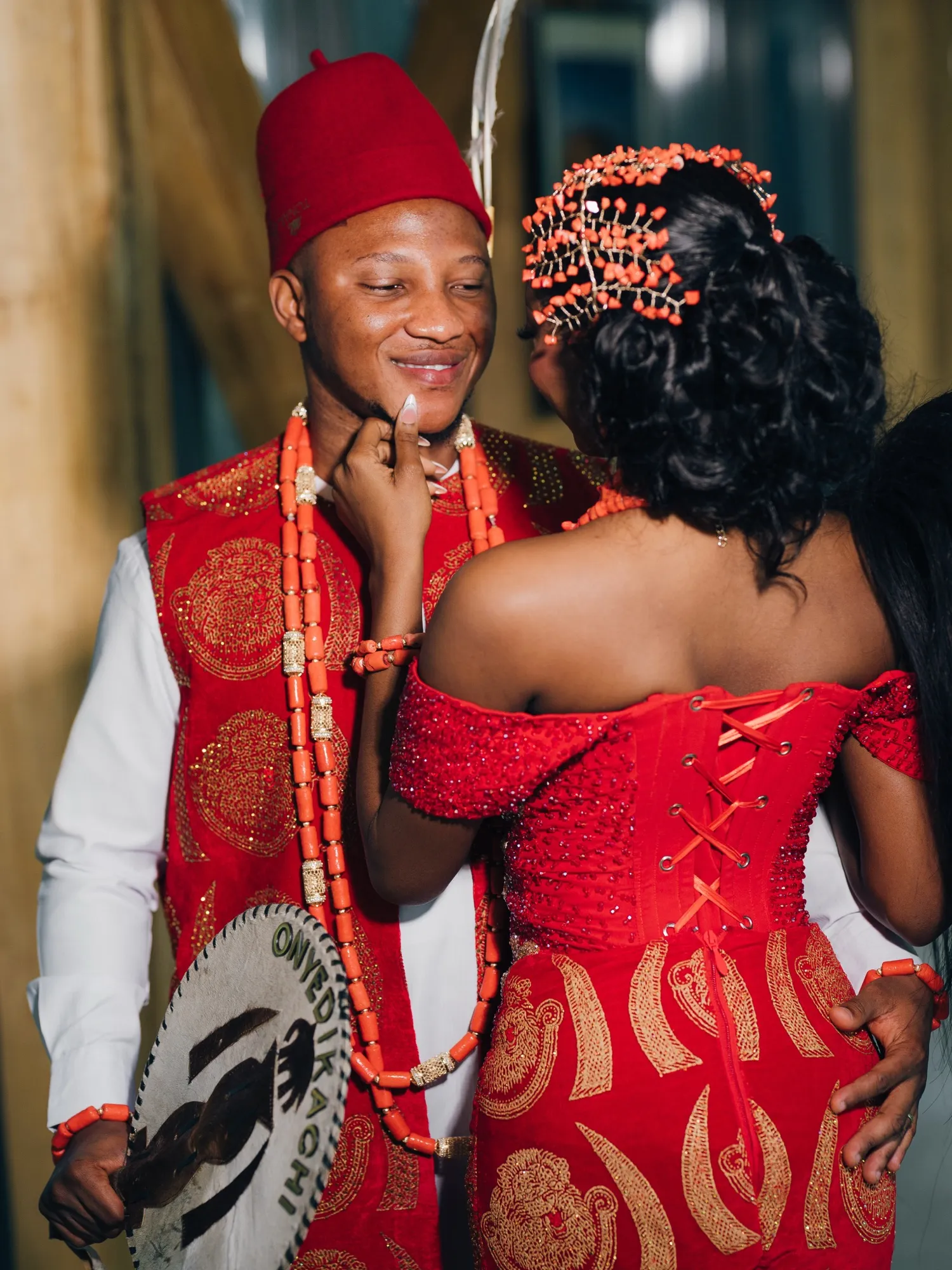 Onyedikachi in a red cap holding Feyi's face