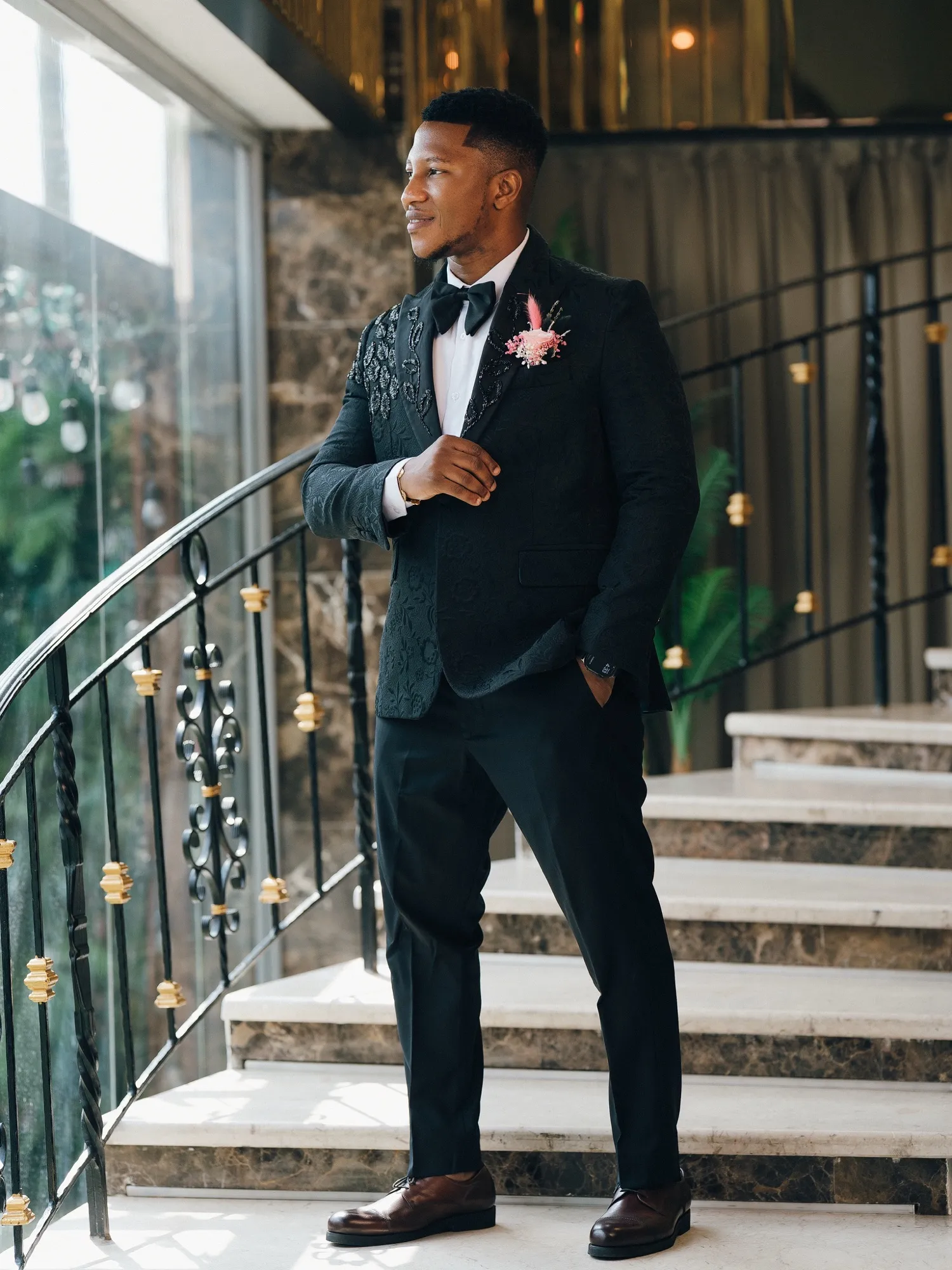 Onyedikachi in a black tuxedo on the staircase