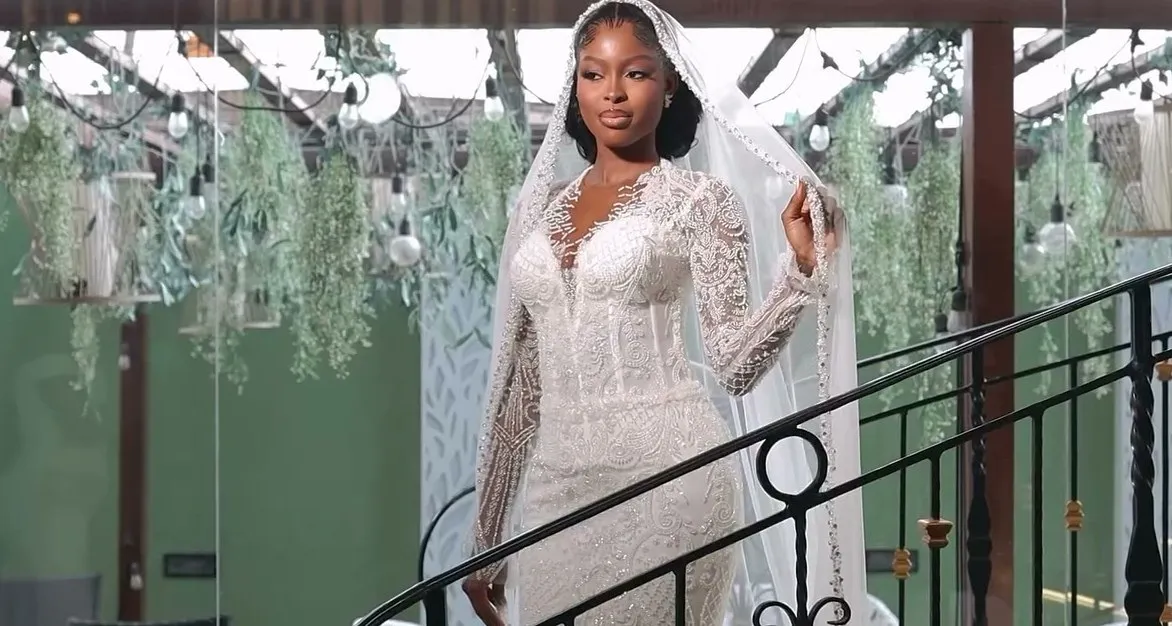 The bride walking down a staircase in her veil