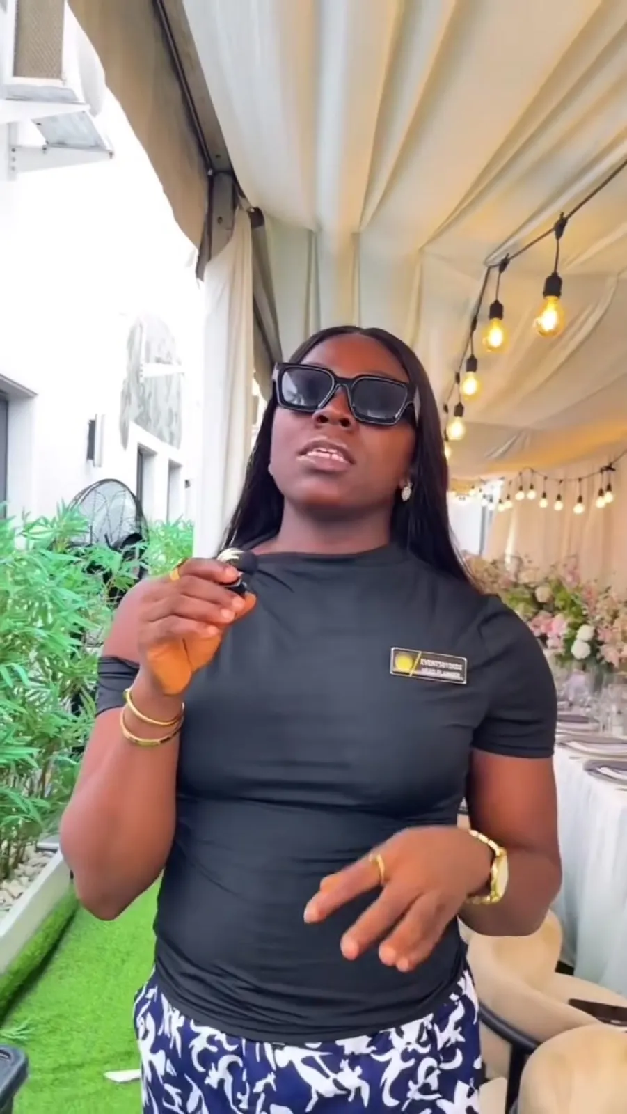 Didi briefing her team on site in sunglasses and a black tee